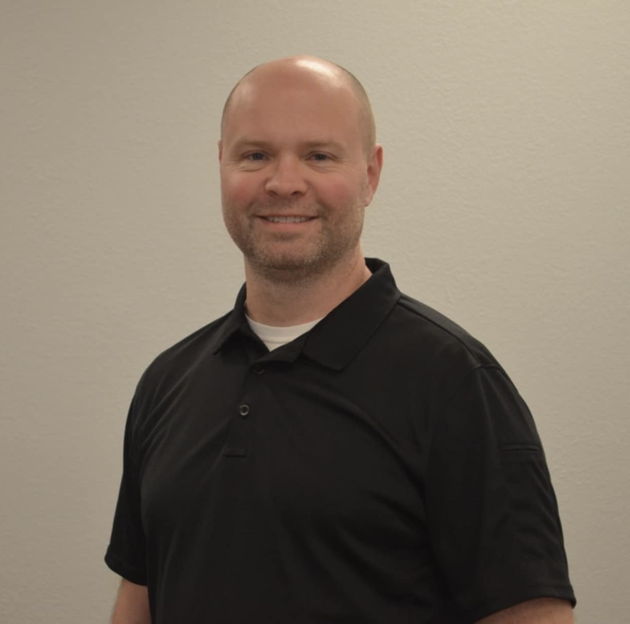 Jonathan Roberts, owner of InfraStretch, smiling in a black polo shirt.